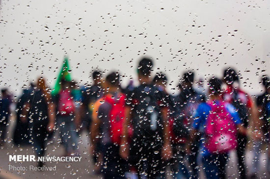 پیاده روی زائران اربعین در هوای بارانی